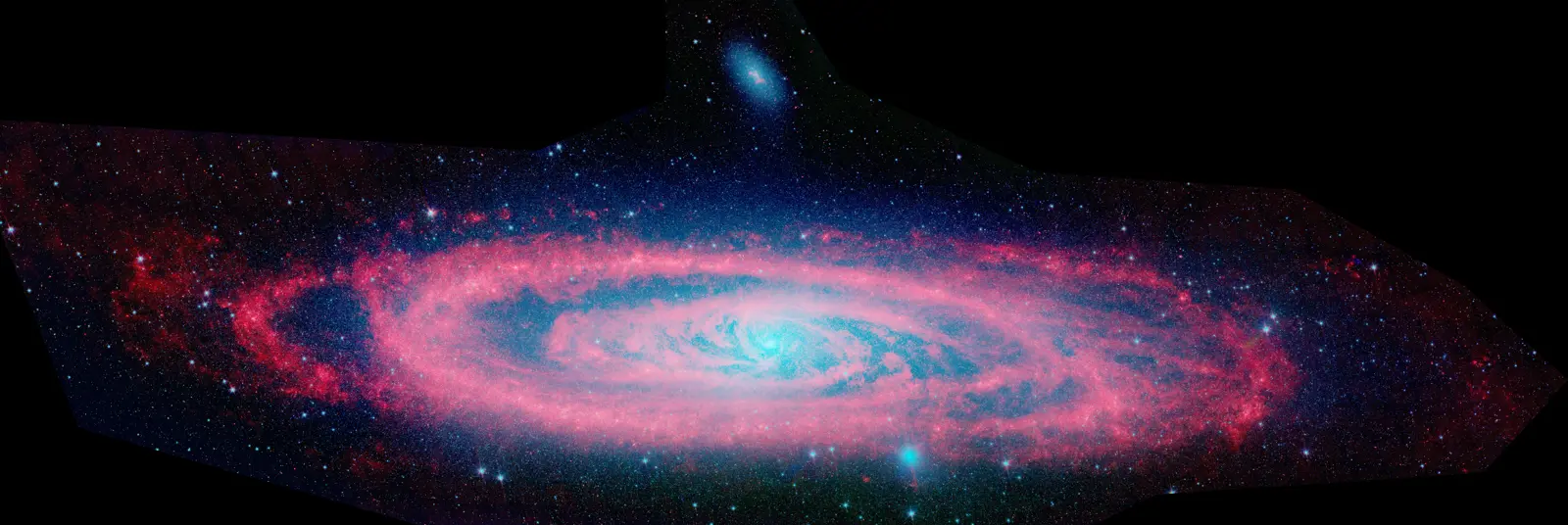 Andromeda Galaxy composite: visible light (NOAO) overlaid with Spitzer infrared data revealing dust-rich star-forming rings (red).